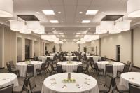 a banquet hall with white tables and chairs and chandeliers at Hyatt Place Chicago O'Hare Airport in Rosemont