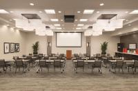 a conference room with tables and chairs and a screen at Hyatt Place Chicago O'Hare Airport in Rosemont