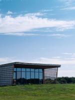 JargalantYeruu lodge的一座大型建筑,在田野上设有窗户