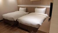 two beds sitting next to each other in a room at Chateau-Rich Hotel in Tainan