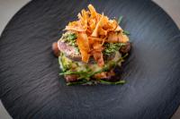 Un plato negro con un sándwich con tocino encima. en Hôtel L'Escale Marine Valdys Resort & SPA, en Douarnenez