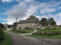 a large brick house on the side of a road at Maison Chabrat in Liginiac