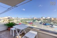 a balcony with a table and chairs and a view of a city at Bright &amp; cosy 3BR home with private balcony &amp; WIFI by 360 Estates in Dingli
