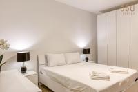 a white bedroom with a bed and two lamps at Bright &amp; cosy 3BR home with private balcony &amp; WIFI by 360 Estates in Dingli