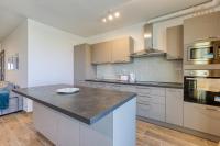 a kitchen with white cabinets and a counter top at Bright &amp; cosy 3BR home with private balcony &amp; WIFI by 360 Estates in Dingli