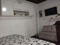 a bedroom with a couch and a tv in a room at Casa com Piscina Paraty in Paraty
