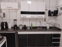 a kitchen with white cabinets and a counter top at Casa com Piscina Paraty in Paraty