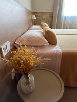 1 dormitorio con 1 cama con un jarrón de flores sobre una mesa en Hostal Barris, en Pals