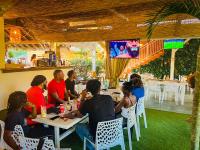 a group of people sitting at a table in a restaurant at Tropicana Suites in Deshaies