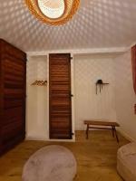 a living room with a wooden door and a bench at Charmant T3 à côté des Thermes in Luxeuil-les-Bains