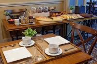 a table with bread and pastries and cups on it at Contact Hôtel du Commerce et son restaurant Côte à Côte in Autun