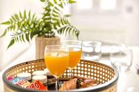 two glasses of orange juice and a basket of food at Appartement chic proche gare de Clamart + Netflix in Malakoff