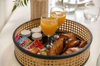 a basket of bread and drinks and a glass of orange juice at Appartement chic proche gare de Clamart + Netflix in Malakoff
