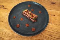 un plato negro con un trozo de comida. en Résidences Valdys Thalasso & Spa de Rockroum, en Roscoff