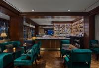 un restaurante con sillas verdes y un bar en Rosewood Washington DC, en Washington