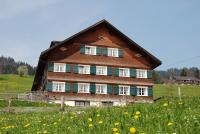 a large wooden house in a field of flowers at Bio Ferienbauernhof Greber in Schwarzenberg