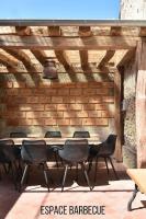 a table and chairs in a room with a brick wall at Plain pied avec terrasse à 5 minutes de Berck in Verton
