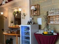 a room with a refrigerator and a table with drinks at Hotel Weinstube am Markt in Gerolzhofen
