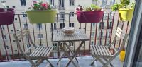 two chairs and a table with potted plants on a balcony at Chambre d&#39;hôte in Saint-Ouen