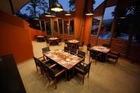 a dining room with tables and chairs and windows at Vyna Hillock Resort in Vythiri