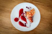 eine weiße Platte mit Essen auf einem Holztisch in der Unterkunft Résidence Valdys Thalasso & Spa - les Pins in Saint-Jean-de-Monts