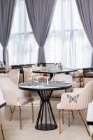 a dining room with two tables and chairs at Shitaye Suite Hotel in Addis Ababa