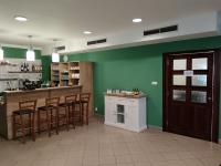 a kitchen with green walls and a bar with stools at Centrum pro vzdělávání a kulturu in Nový Oldřichov