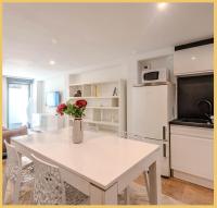 a kitchen with a white table with a vase of flowers on it at Appart T3 Luxe Douvaine in Douvaine