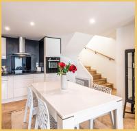 a kitchen with a white table with a vase of flowers on it at Appart T3 Luxe Douvaine in Douvaine