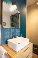 La salle de bains est pourvue d&#39;un lavabo blanc et d&#39;un miroir. dans l&#39;établissement Hotel de La Paix, à La Rochelle