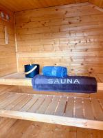a wooden sauna with a blue towel and two cups at LUXUS sApartments in der Kunstvilla &amp; kostenloses parken in Premstätten