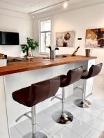 a kitchen with a counter and two bar stools at LUXUS sApartments in der Kunstvilla &amp; kostenloses parken in Premstätten