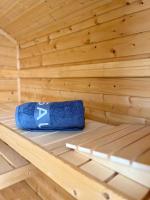 a wooden sauna with a blue towel sitting on a bench at LUXUS sApartments in der Kunstvilla &amp; kostenloses parken in Premstätten