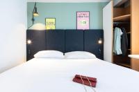 a bedroom with a large white bed with a black headboard at ibis Paris Bastille Faubourg St Antoine in Paris