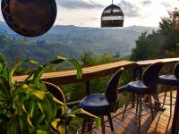 balcón con sillas y vistas a las montañas en Omghat Glamping - Cabaña Shiva, en El Peñol