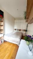 ein Schlafzimmer mit einem Bett und einem Tisch mit Blumen in der Unterkunft Charmant Appartement moderne Paris 13e in Paris