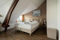 a bedroom with a large white bed in a attic at Best Western Hotel De La Plage Saint Marc sur Mer in Saint-Nazaire