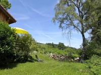 a yellow umbrella and a chair in the grass at Modern apartment in Soultzeren in Soultzeren