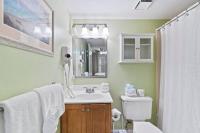 ein Badezimmer mit Waschbecken, Toilette und Spiegel in der Unterkunft Beachfront condo at Pelican Beach in Destin