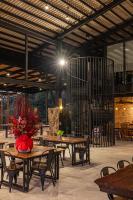 un restaurante con mesas de madera, sillas y flores en Sebayu Retreat Gopeng, en Gopeng