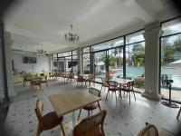 Un comedor con mesas y sillas y una piscina. en Roman Resort Phú Quý - Đảo Phú Quý, Bình Thuận, en Cu Lao Thu