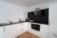 a white kitchen with a sink and a microwave at Louisappart - Eupen Zentrum in Eupen