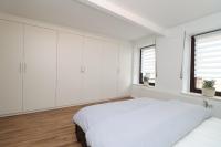 a white bedroom with white cabinets and a bed at Louisappart - Eupen Zentrum in Eupen