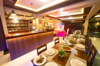 a restaurant with a long table with plates of food at Casañas Suites in Puerto Princesa City