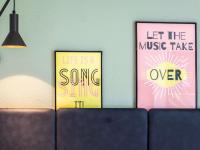 three posters hanging on a wall next to a couch at ibis Paris Bastille Faubourg St Antoine in Paris