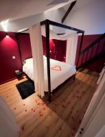 - une chambre avec un lit à baldaquin dans l&#39;établissement 50 Nuances d&#39;Amour - Jacuzzi &#47; Massage &#47; Cinéma, à Moirans