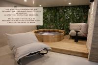 a wellness room with a tub and a chair at Atypik Hotel in Clichy