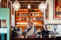 Un hombre de pie detrás de una barra sirviendo vino en 1448 Antica Dimora Al Merlo Bianco, en Cividale del Friuli