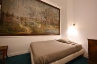a bed in a room with a large painting on the wall at Hotel Esmeralda in Paris