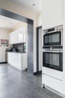 a large kitchen with white cabinets and a microwave at Wonderful luxury house at 10min from Paris in Meudon